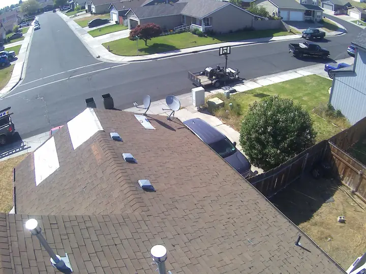 Completed shingle roof with skylights in a residential neighborhood